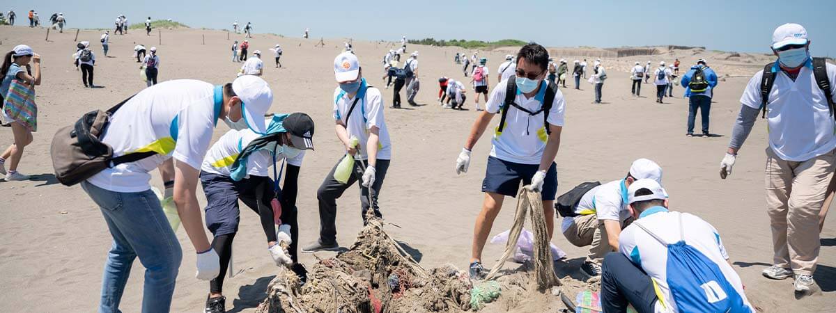企業家庭日主題ESG淨灘活動 員工同仁們合作在沙灘上整理環境